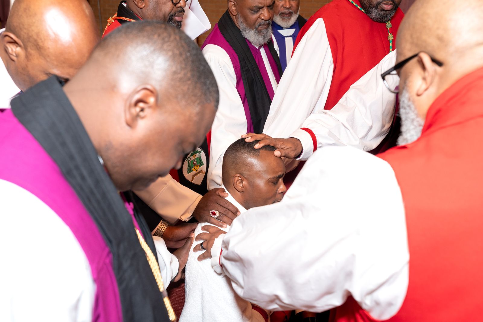 Bishops laying their hands on the head of the Bishop-elect in prayer