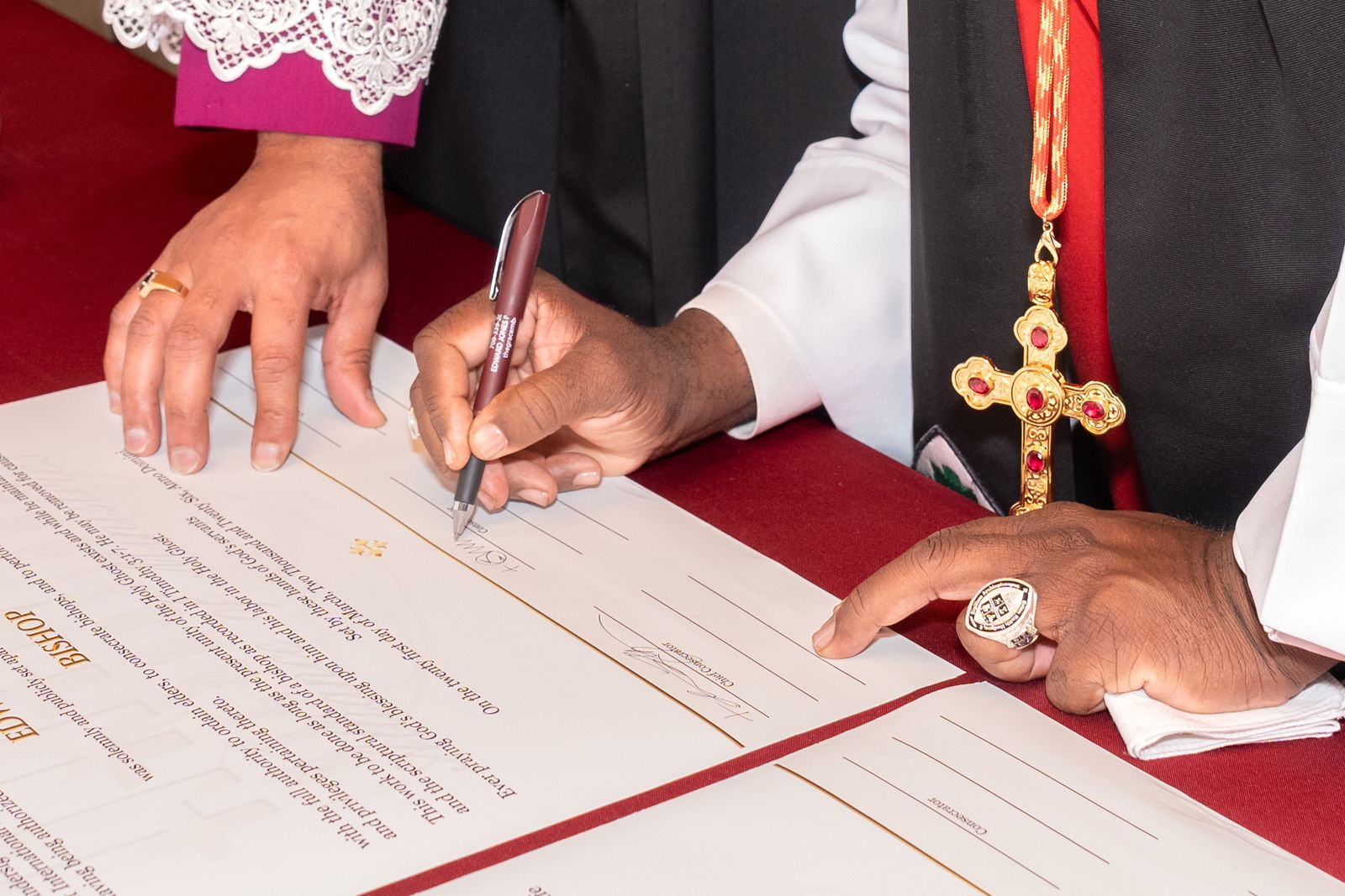 A bishop’s hand signing the Certificate of Consecration