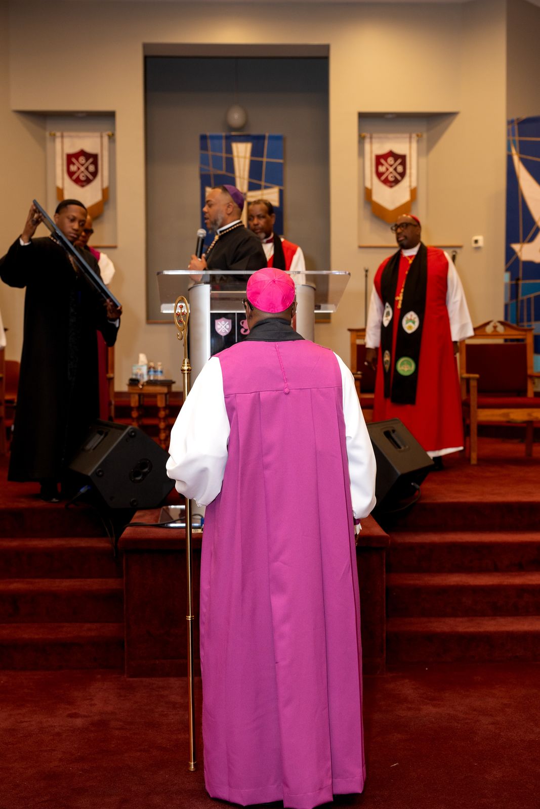 Bishop Jones, seen from behind in purple, facing the altar