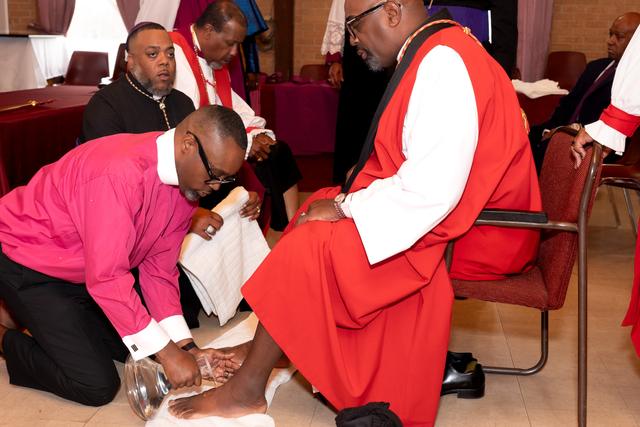 The Bishop-elect washing the feet of a bishop in red