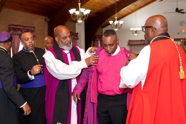 The Bishop-elect being robed in purple