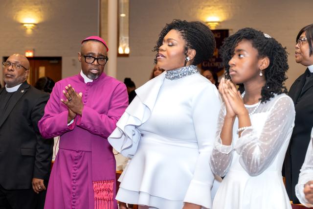 The Bishop-elect and his family clapping in worship