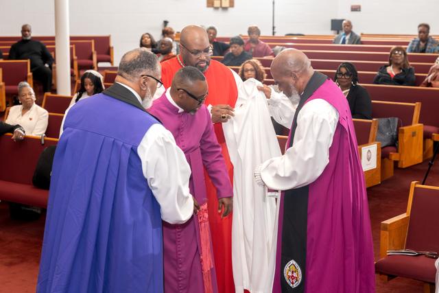 Bishops robing the newly consecrated Bishop in white