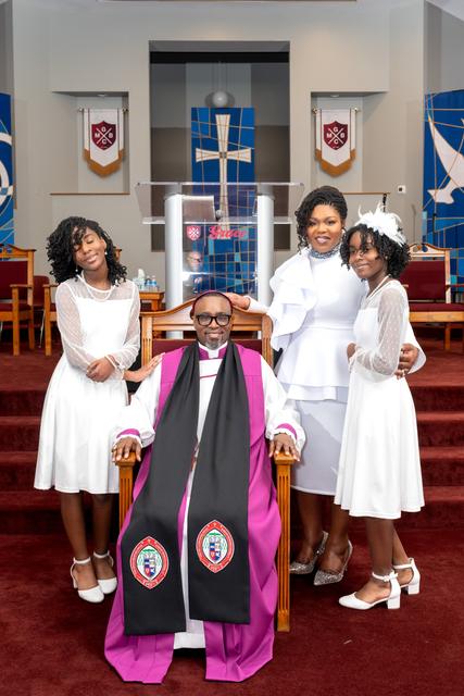 Bishop Jones seated in his robes with his family around him